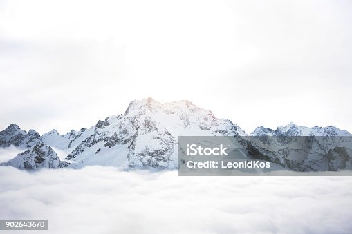 istock Snowy mountains above the clouds. Great winter massif of rocks 902643670
