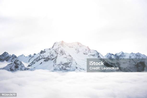 Snowy Mountains Above The Clouds Great Winter Massif Of Rocks Stock Photo - Download Image Now