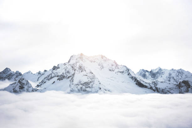 снежные горы над облаками. большой зимний массив скал - mountain rock sun european alps стоковые фото и изображения