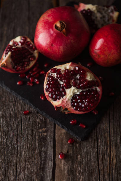 istock Pomegranate fruit lies on the dark board. 902647642