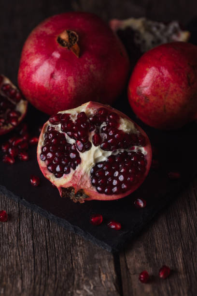 istock Pomegranate fruit lies on the dark board. 902647682