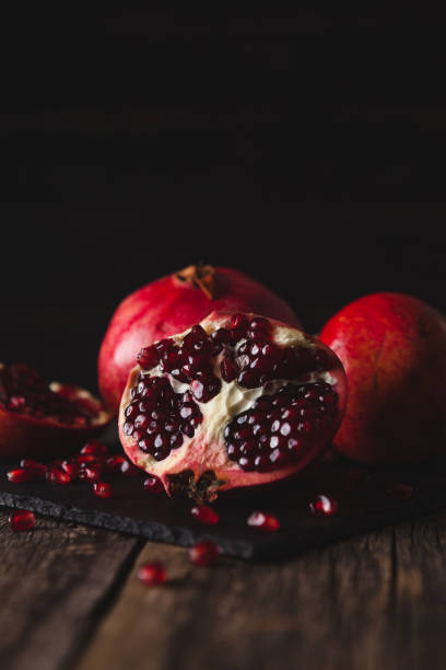 istock Pomegranate fruit lies on the dark board. 902647758