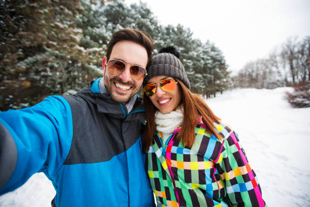 istock Romantic couple taking snow selfie 902651032