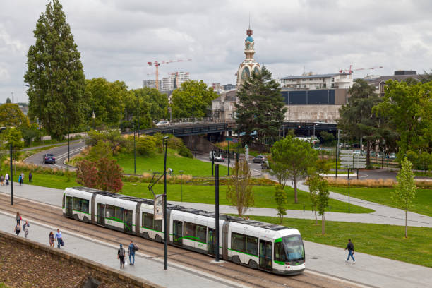Nantes tramway passing before the Lieu Unique Nantes, France - July 26 2017: The Tramway de Nantes (Nantes tramway) passing before the Lieu Unique, a national center for contemporary arts and music venue housed in the former biscuit factory "LU" at the center of the city. nantes stock pictures, royalty-free photos & images