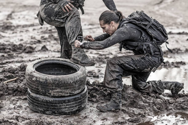 istock Female drill instructor training shaved male soldier outdoors in the mud 902651506