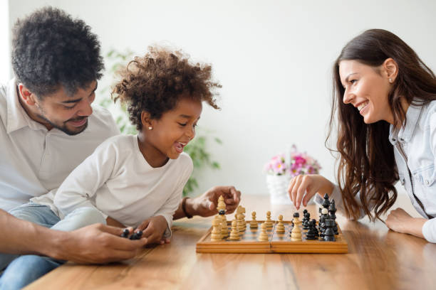 istock Happy family playing chess together 902652082