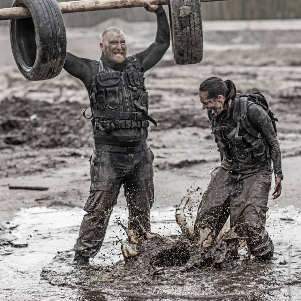 istock Female drill instructor training shaved male soldier outdoors in the mud 902652112