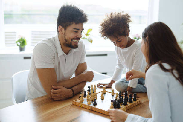 istock Happy family playing chess together at home 902652304