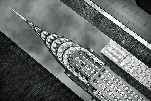 Monochrome abstract Chrysler building framed by nearby buildings at a junction as it looms above Lexington Avenue, NYC