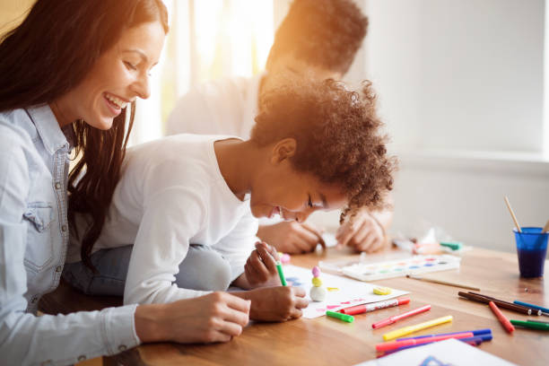 istock Mother and father drawing together with their child 902655232