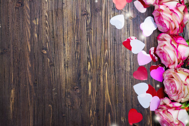 istock Beautiful pink rose, decorative confetti hearts on Valentines day background 902657804