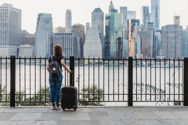 Young woman travelling in New York Young woman travelling in New York with suitcase wheeled luggage stock pictures, royalty-free photos & images