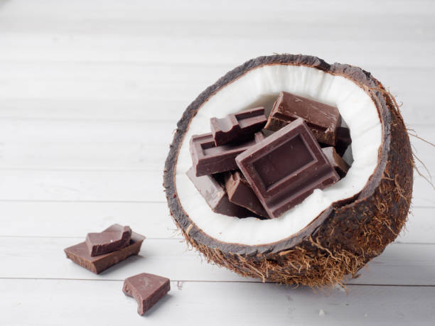 istock Fresh organic coconut broken into two parts with chocolate on a rustic wooden background 902662818