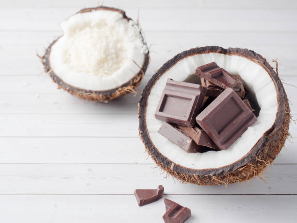 istock Fresh organic coconut broken into two parts with chocolate on a rustic wooden background 902662942