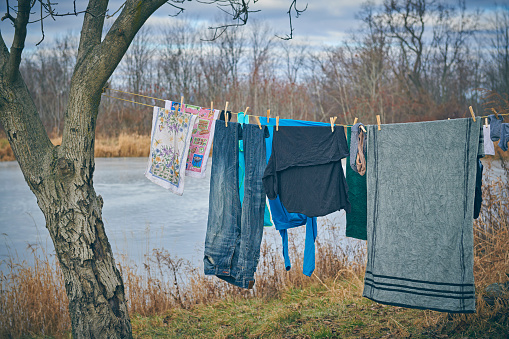 Laundry drying outdoors on a line hanging from a tree to the house. Retro style clothes