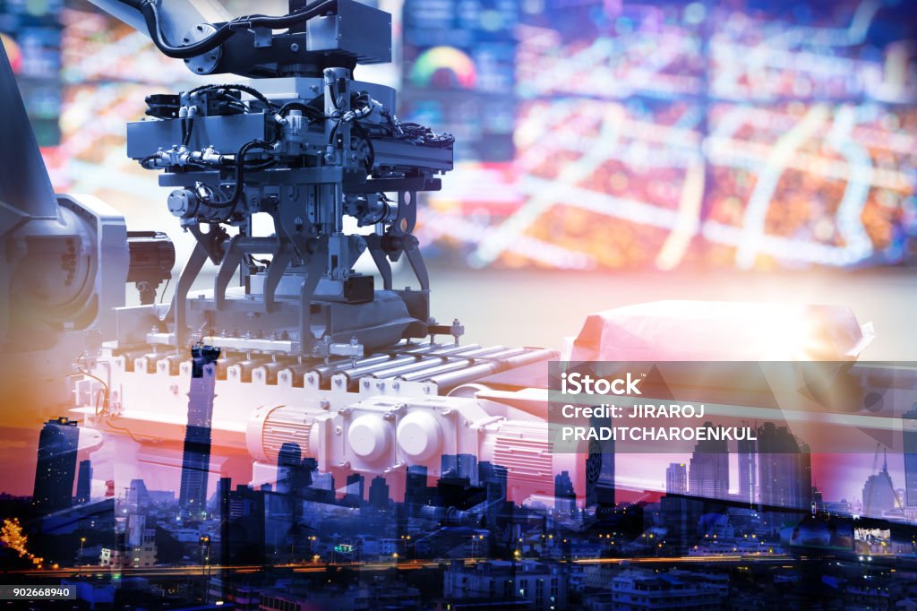 Industrial internet of things , smart logistic  and industry 4.0 concept. Abstract blue tone background of automation control robotic machine arm . metro city in smart factory with flare light effect. Car Plant Stock Photo