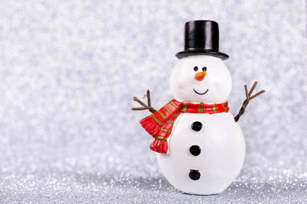istock Snowman toy on shiny silver background 902669866