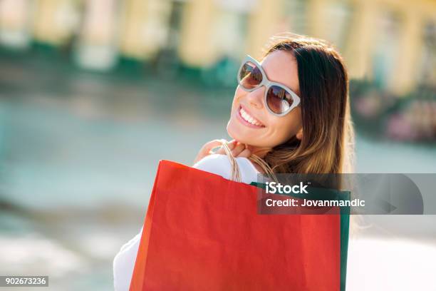 Beautiful Woman Holding Shopping Bags And Smiling Outdoors Stock Photo - Download Image Now