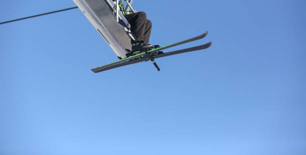 istock Skier ascending a slope on a ski lift beautiful day 902676780