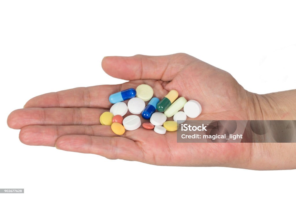 Senior woman holding assorted capsules in her hands. Conceptual of health care for the elderly. Adult Stock Photo