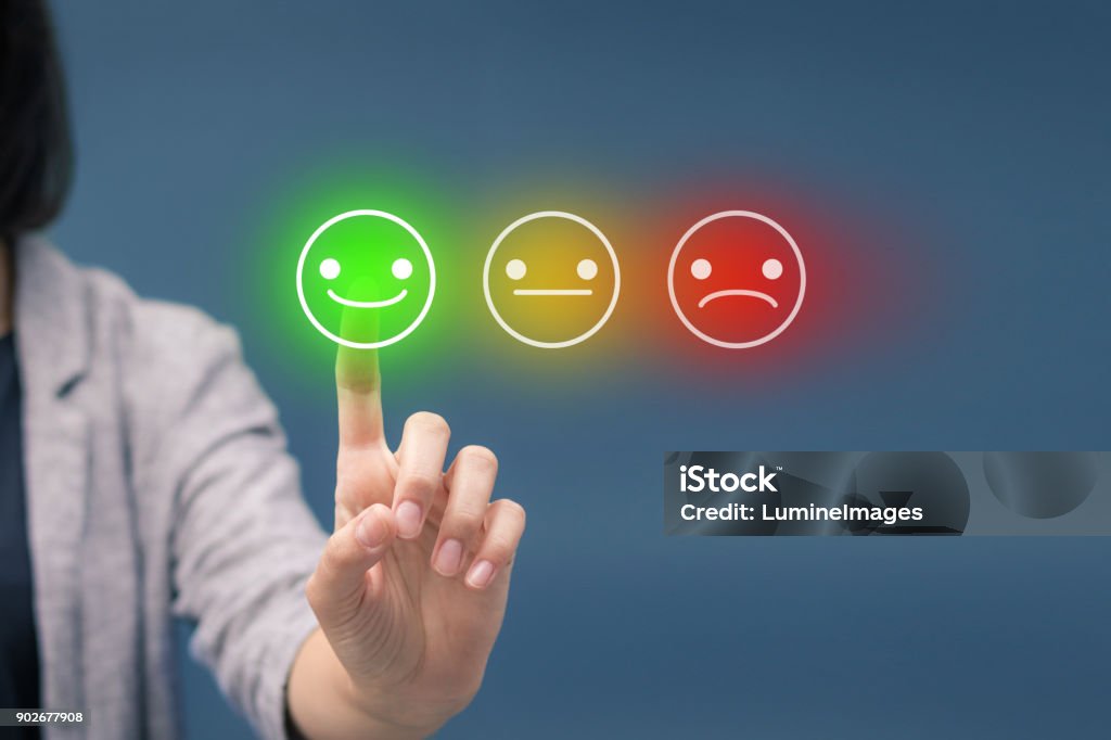 Evaluating customer service satisfaction. Woman pressing happy smiley face emoticon on virtual touch screen. Customer service rating concept. Questionnaire Stock Photo