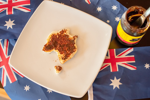 Yeast extract spread on toast shaped like Australia with the Austrian flag in the image.