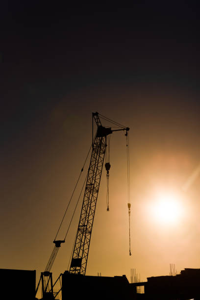 istock silhouette tower·crane of construction site at sunset 902680856