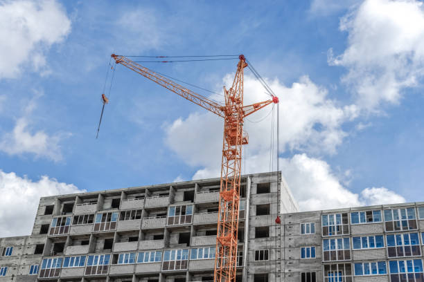 istock Abstract Industrial background with construction cranes silhouettes over amazing sky. cranes 902681058