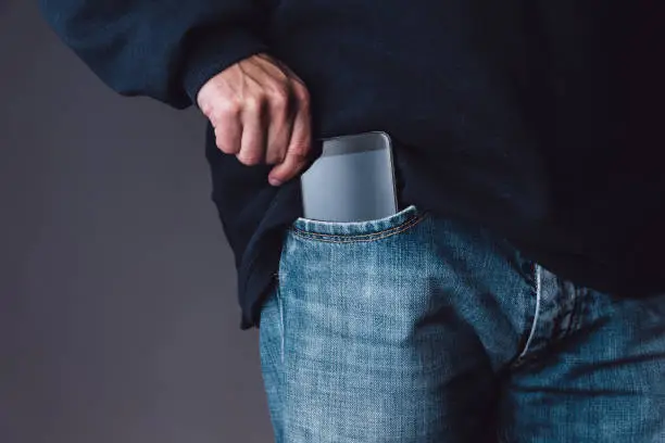 Smartphone on a caucasian young adult male jeans pocket.