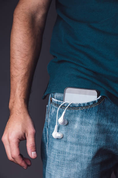 istock Mobile phone on pocket with hanging headphones 902681504