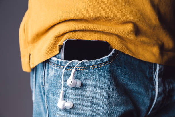 istock Mobile phone on pocket with hanging headphones 902681576