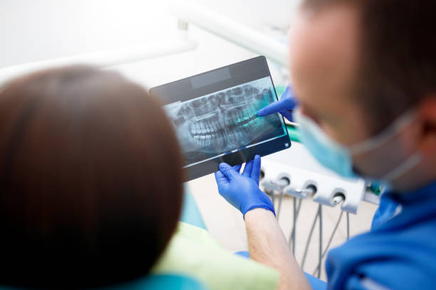 istock Dentist showing a patient her x-ray 902684112