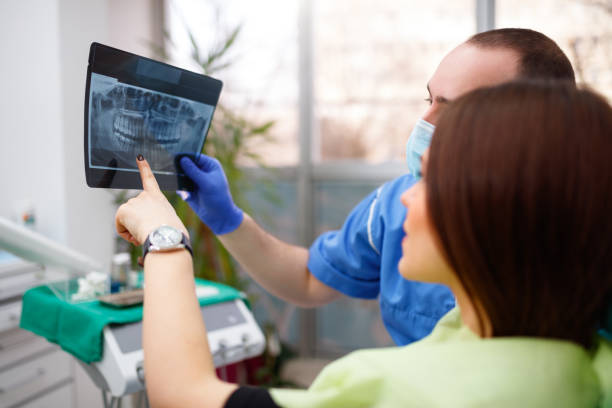 istock Dentist showing a patient her x-ray 902684462