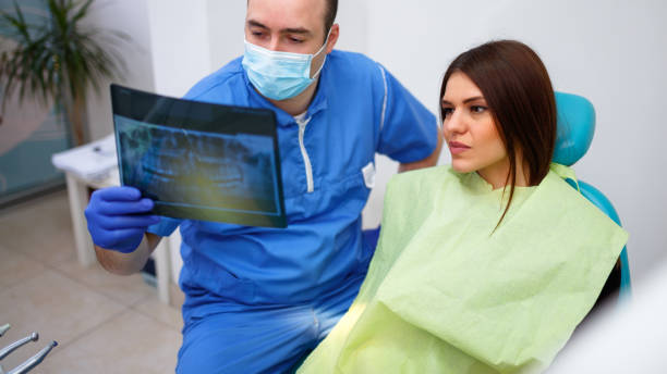 istock Dentist showing a patient her x-ray 902686806