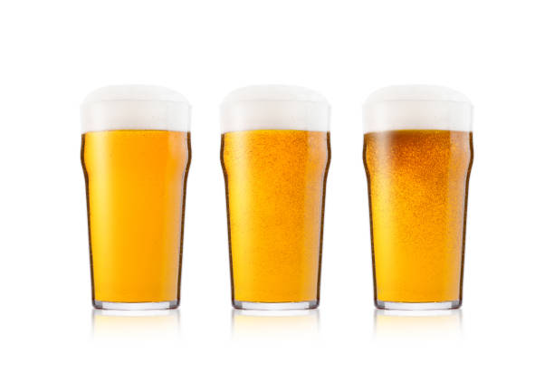 Cold elegant glasses of lager beer with foam and dew isolated on white background