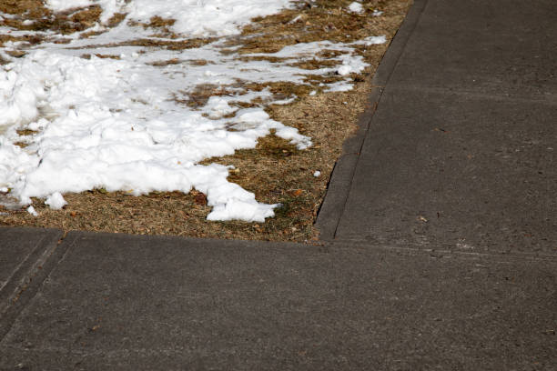 istock Corner in a sidewalk with dead grass and snow 902706644