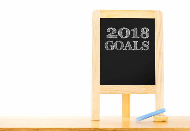 istock 2018 goals on blackboard with easel on table isolated on white background,Mock up for adding your backdrop,clipping path object. 902713032