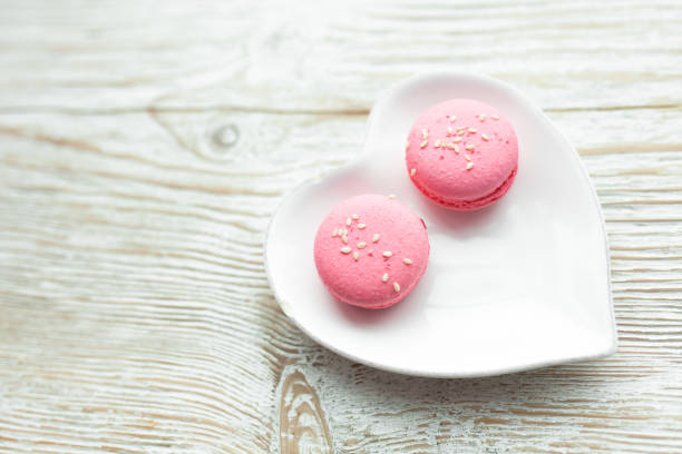 istock Delicious fresh macaroons on the plate is heart-shaped, lovers 902719260