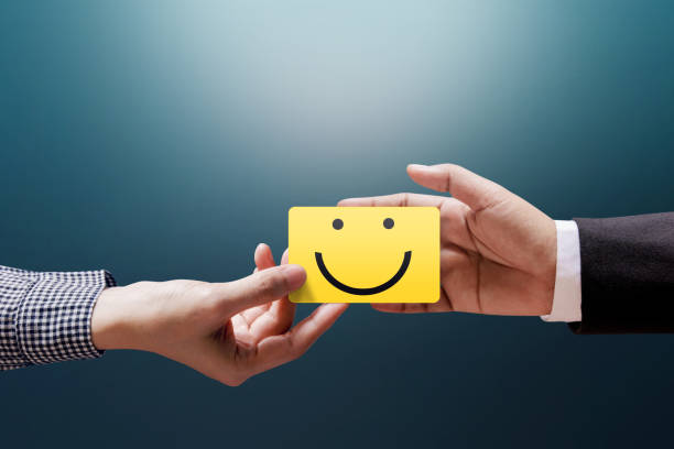istock Customer Experience Concept, Happy Client Woman giving a Feedback with Happy Smiley Face Card into a Hand of Businessman 902722728