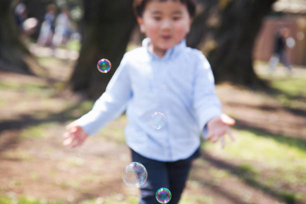 Boy chasing after soap bubbles.