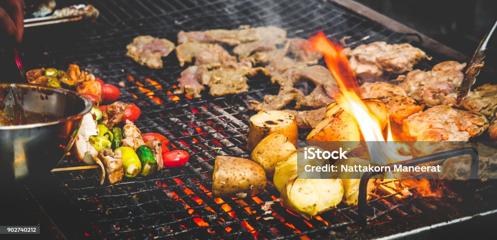 Man's hand cooking grill barbecue/steak with fire Barbecue Grill Stock Photo