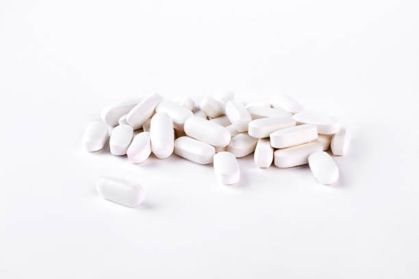 istock White medical pills on white background. 902745976