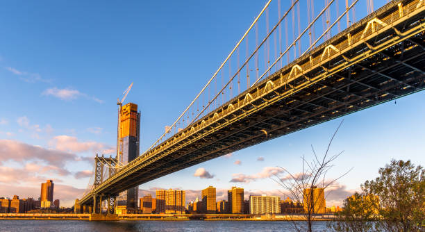 istock Manhattan Bridge and skyline silhouette view from Brooklyn at sunset 902750134