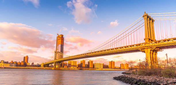 istock Manhattan Bridge and skyline silhouette view from Brooklyn at sunset 902750498