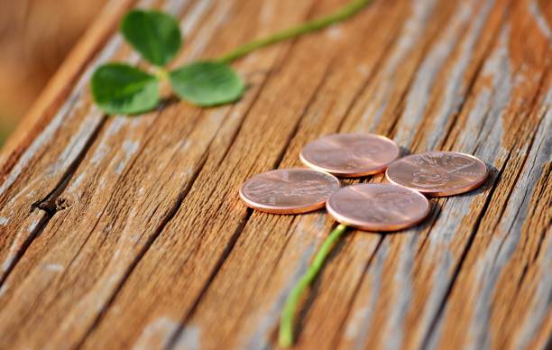 Four-leaf clover from pennies on wood.
