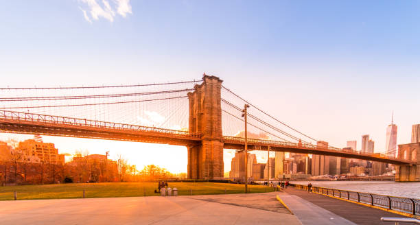 Brooklyn bridge promenade at sunset with Manhattan skyline stock photo