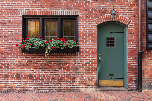 brick facade with an aqua colored door with window planters