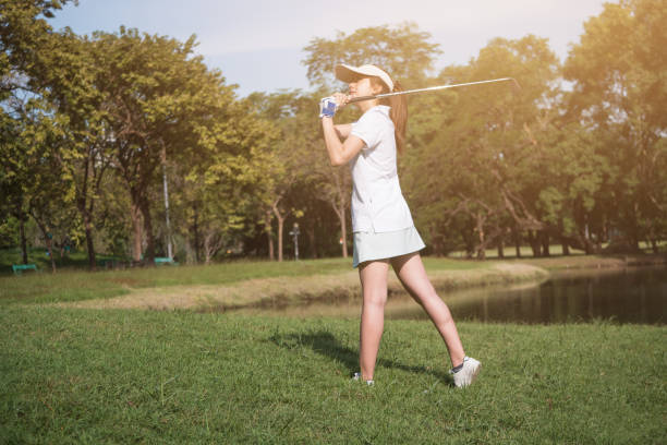 istock Asian woman golf player swinging driver golf club on golf course. 902761450