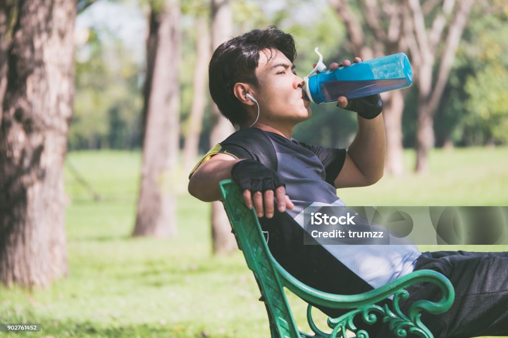 A man fresh up himself after exercise by drinking fresh water. Adult Stock Photo