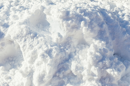 close up of pile of soft and fluffy white snow on bright sunny day, showing great texture details